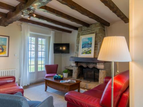 LandunvezにあるHoliday Home Saint Gonvel - LDZ103 by Interhomeの赤い家具と石造りの暖炉付きのリビングルーム