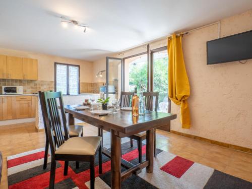 une cuisine et une salle à manger avec une table et des chaises en bois dans l'établissement Apartment Il était une fois-2 by Interhome, à Saint-Aygulf