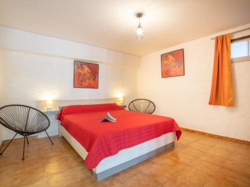 - une chambre avec un lit rouge et deux chaises dans l'établissement Apartment Il était une fois-2 by Interhome, à Saint-Aygulf