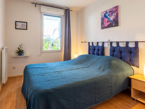 une chambre avec un lit bleu avec une fenêtre dans l'établissement Apartment Hortensia by Interhome, à Cabourg