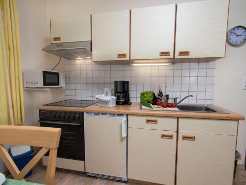 a small kitchen with a sink and a stove at Apartment Strandkorb by Interhome in Norddeich
