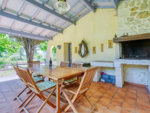 une salle à manger avec une table et une cheminée dans l'établissement Holiday Home Nola - GEM100 by Interhome, à Gaillan-en-Médoc