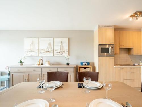 ブレーデネにあるApartment Residentie Lautrec-1 by Interhomeのキッチン、ダイニングルーム(ワイングラス付きのテーブル付)