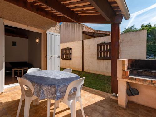 un patio avec une table, des chaises et un barbecue dans l'établissement Holiday Home La Pinède- bungalow 4 pers- by Interhome, à Sagone