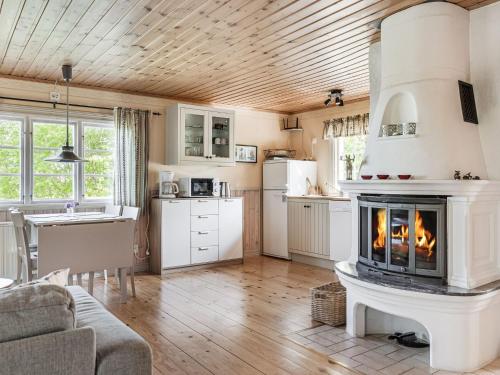 Il dispose d'une cuisine et d'un salon avec une cheminée. dans l'établissement Holiday Home Lunnekullen - VGT122 by Interhome, à Tibro