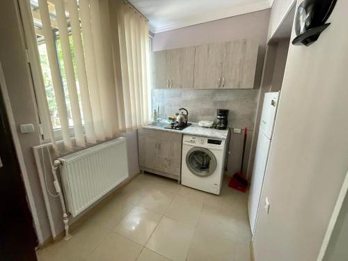 uma pequena cozinha com uma máquina de lavar roupa e uma máquina de lavar roupa em Ekas apartamenti em Tbilisi