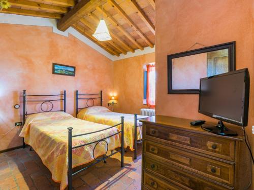 a bedroom with two beds and a flat screen tv at Holiday Home La Casina by Interhome in Rinecchi