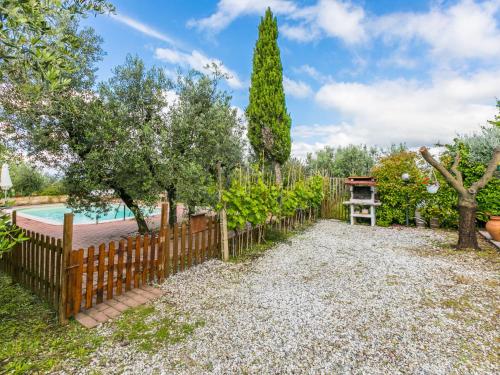 a garden with a wooden fence and a pool at Holiday Home La Casina by Interhome in Rinecchi