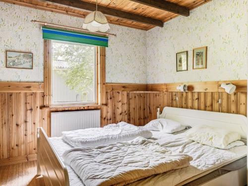 a bedroom with a large bed in a room with wooden walls at Holiday Home Ängasjö by Interhome in Östra Frölunda