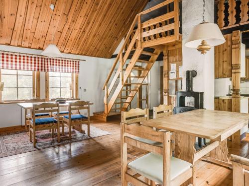 a dining room with a table and chairs and wooden ceilings at Holiday Home Ängasjö by Interhome in Östra Frölunda