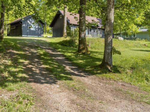 a dirt road in front of a barn with trees at Holiday Home Ängasjö by Interhome in Östra Frölunda