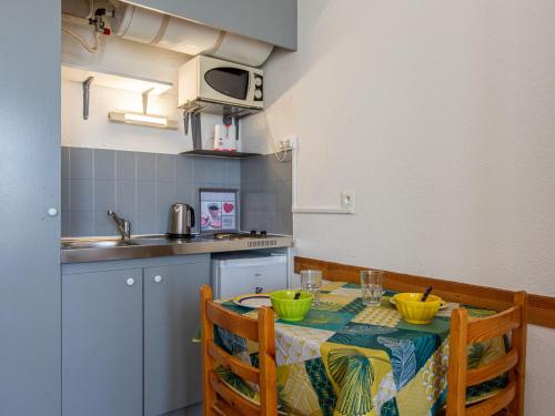 a small kitchen with a table with a table cloth at Apartment Trinquart-1 by Interhome in Seignosse