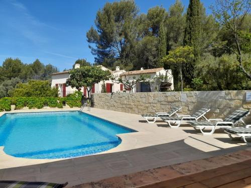 une piscine avec des chaises et une maison en arrière-plan dans l'établissement Apartment Le Mas Line by Interhome, à Le Brulat