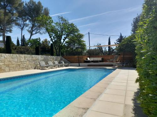 een zwembad met blauw water in een tuin bij Apartment Le Mas Line by Interhome in Le Brulat