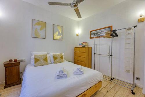 une chambre avec un lit blanc et un ventilateur de plafond dans l'établissement New - 1 Bed Apt Central Antibes, à Antibes