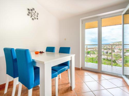 une salle à manger avec une table blanche et des chaises bleues dans l'établissement Apartment Miškulin-1 by Interhome, à Senj