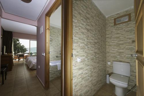 a bathroom with a toilet and a bedroom with a tub at Hotel Dar Eddaya in Khemisset