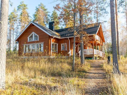 una cabaña de madera en el bosque con un camino delante en Holiday Home Lokinsiipi by Interhome en Vähäsalmi