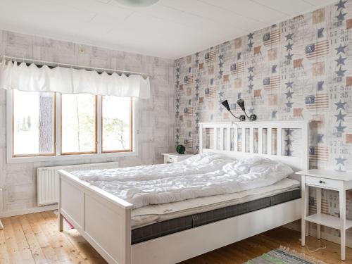 ein weißes Schlafzimmer mit einem großen weißen Bett und einem Fenster in der Unterkunft Chalet Löaborn by Interhome in Kopparberg