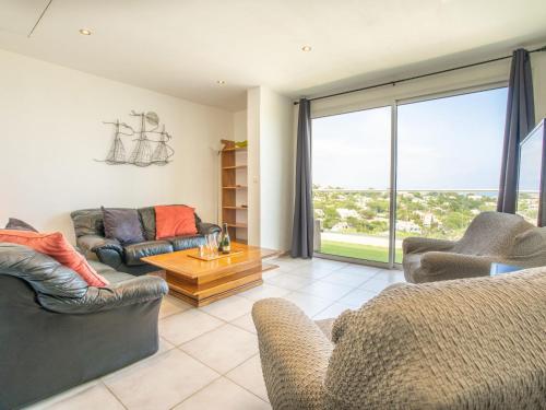 a living room with couches and a large window at Villa Les 4 Vents by Interhome in Saint-Aygulf