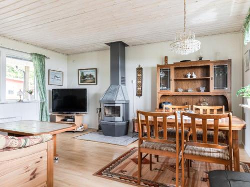 - un salon avec une table et un poêle à bois dans l'établissement Holiday Home Gissarp Gryningen by Interhome, à Nässjö