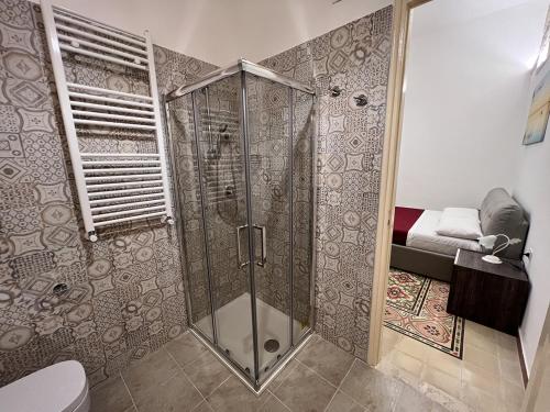 a bathroom with a shower with a toilet and a bed at Osorio 74 Apartments in Trapani
