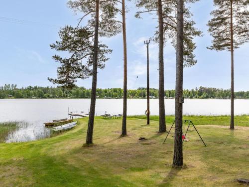 a picnic area next to a lake with trees and a swing at Holiday Home Gissarp Gryningen by Interhome in Nässjö