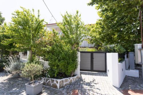 a garage with trees in front of a house at Anastasia Studios Hanioti in Hanioti