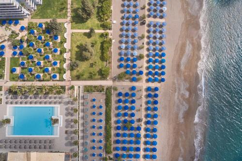 an overhead view of a beach with blue umbrellas at Esperides Beach Resort in Faliraki