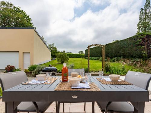 uma mesa cinzenta com cadeiras e uma garrafa de vinho em Holiday Home Cannelle - L em Saint-Symphorien-le-Valois