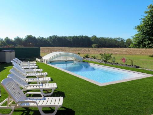 une rangée de chaises de jardin à côté d'une piscine dans l'établissement Villa Maroye by Interhome, à Soustons