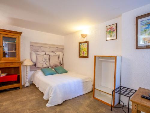 une chambre avec un grand lit blanc avec des oreillers verts dans l'établissement Studio Village de Bormes les Mimosas by Interhome, à Bormes-les-Mimosas