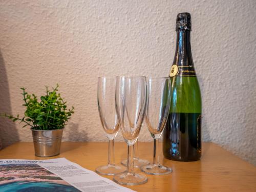 een fles wijn en drie wijnglazen op een tafel bij Apartment Le Mas des Calanques-1 by Interhome in Saint-Aygulf