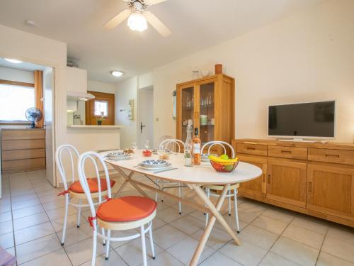 een keuken met een tafel en stoelen en een televisie bij Apartment Le Mas des Calanques-1 by Interhome in Saint-Aygulf