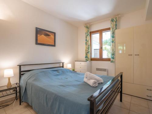 une chambre avec un lit bleu et une fenêtre dans l'établissement Apartment Le Mas des Calanques-1 by Interhome, à Saint-Aygulf
