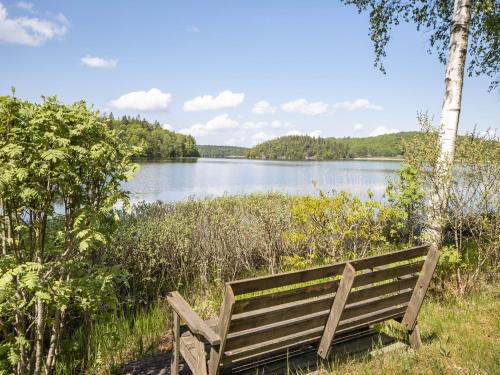 a wooden bench sitting in front of a lake at Holiday Home Dammeberg by Interhome in Karl Gustav