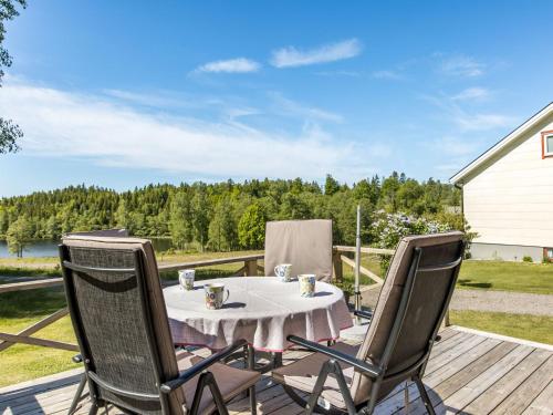 a table and chairs on a deck with a view of a lake at Holiday Home Mjöhult Utsikten by Interhome in Ätran