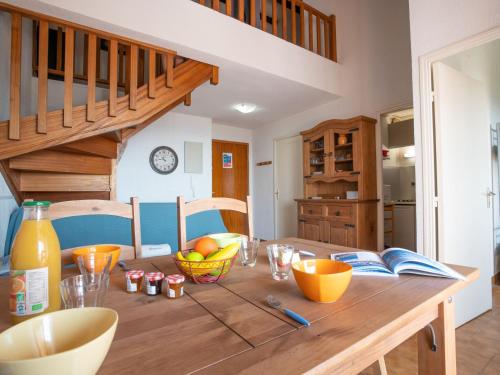 a kitchen with a wooden table with bowls of fruit at Apartment Le Victoria-2 by Interhome in Saint-Aygulf