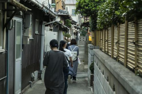 a group of people walking down a alley at Guesthouse SETOUCHI LIFE in Kure
