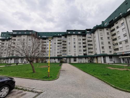 a large apartment building with a car parked in front of it at Family apartment Tuzla (100 m2) in Tuzla