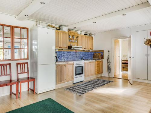 a kitchen with a white refrigerator and wooden cabinets at Holiday Home Ängasjö Ekbacken by Interhome in Östra Frölunda
