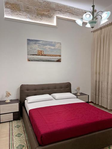a bedroom with a large bed with a red blanket at Osorio 74 Apartments in Trapani