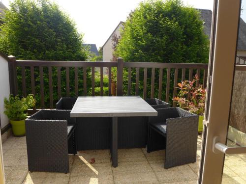 une table blanche et des chaises sur un balcon dans l'établissement Apartment Les Christophines-3 by Interhome, à Cabourg