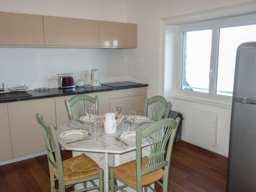 Il comprend une cuisine équipée d'une table et de chaises. dans l'établissement Apartment Les Nielles by Interhome, à Saint-Malo