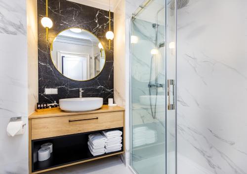 a bathroom with a shower and a sink and a mirror at Bentis Luxury Apartments in Kraków