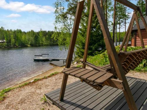 a hammock sitting on a deck next to a river at Holiday Home 7152 by Interhome in Kaartilankoski
