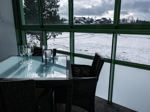 a table with wine glasses and a view of the snow at Apartment F 96 by Interhome in Dittishausen