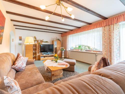 ein Wohnzimmer mit einem Sofa und einem TV in der Unterkunft Apartment Am Hohen Bogen-25 by Interhome in Arrach