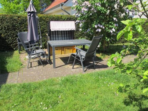 una mesa y dos sillas y una sombrilla en un patio en Holiday Home Villa Meike - Insel Poel by Interhome en Kaltenhof