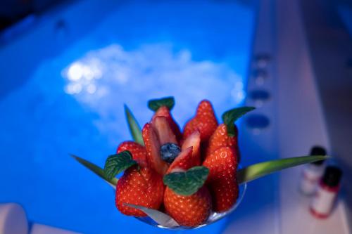 a bowl of strawberries sitting on a blue table at Motel Emoções in Nogueira da Regedoura